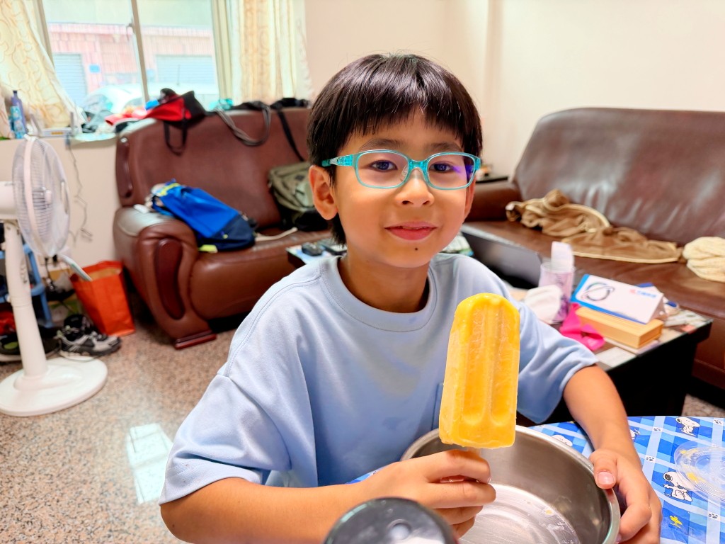小朋友開心吃芒果冰棒解暑
